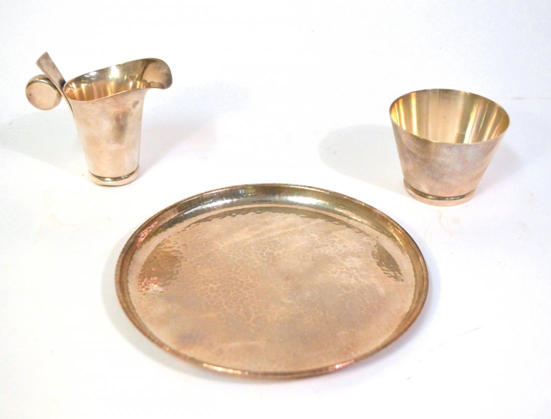 3-Piece Allan Adler Sterling Set: Comprises a modern open sugar bowl and creamer with circular handle. Accompanied by a Martelé tray. All signed "Allan Adler Sterling". Creamer dented at base. 18.62 ozt.