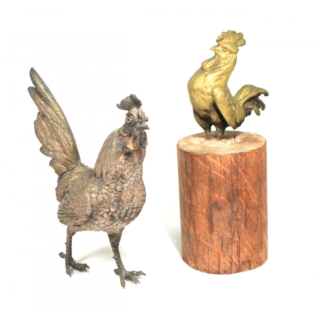 Two Sculptures - Models of Roosters: The first a silvered bronze naturalistically modeled example with red glass eye (one missing). The second, a smaller bronze rooster perched on wood base. [Larger: 7" H]. Both good condition.