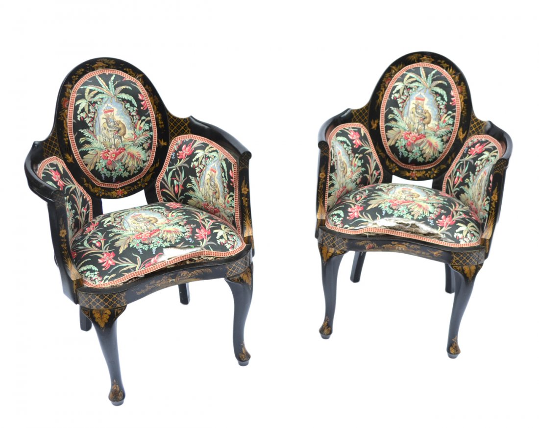 Pair of Chinoiserie Bergeres: Pair of chinoiserie black lacquered chairs having chinoiserie upholstery . [34 1/2" H x 19 1/2" D x 17" to seats]. Fabric torn and scratches.