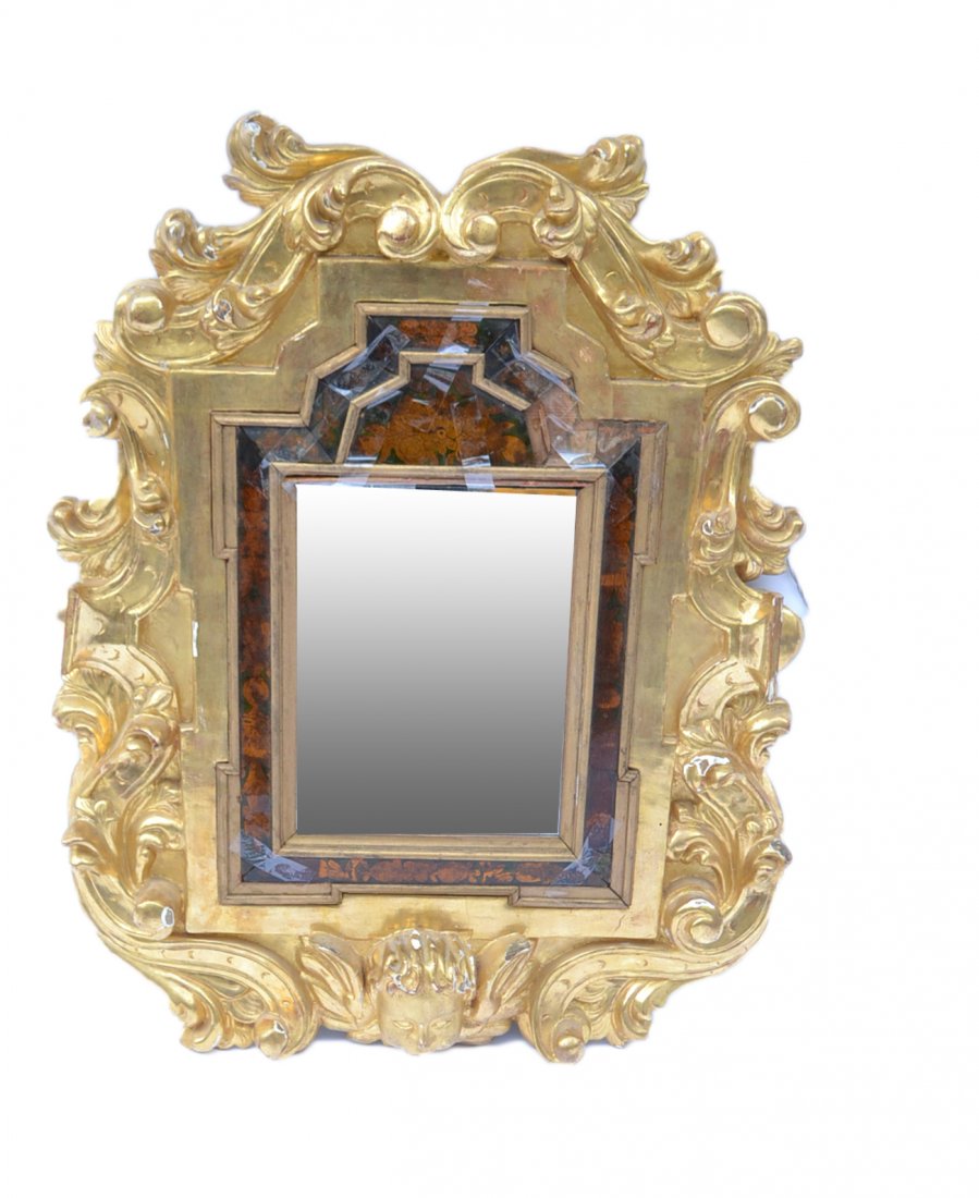 Ornate 19th Century Gilt Wood Mirror: Antique gilt wood mirror, eglomise trim, having a cherub motif at base. Good condition as with age. Eglomise panels damaged. [21 1/2" x 27 3/4"].