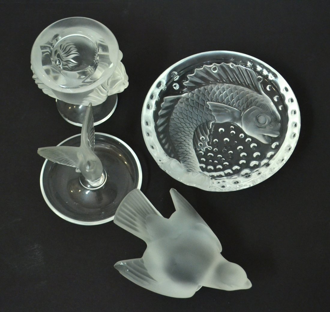 4 Lalique Colorless Glass Articles: Comprises two birds, small vase with lion masks and dish with molded fish. Larger bird bears chip to wing, otherwise in good condition. [H of vase: 3 3/4"].