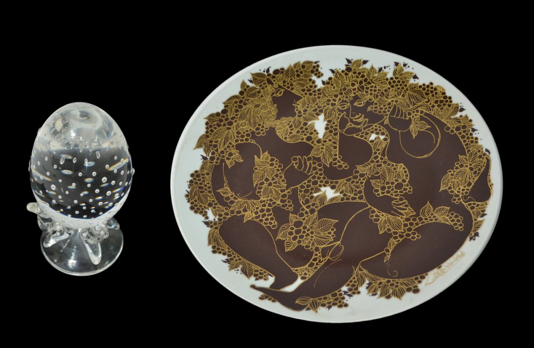 Two Modern Decorative Articles: Comprises a Bjørn Wiinblad porcelain charger and a Steuben glass egg. Both in good condition. [Dia of charger: 13 1/4"].