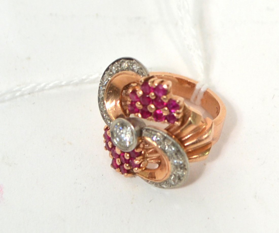 1940's Ladies Cocktail Ring: A 14k rose gold & palladium ring mounted with a round cut diamond and further embellished with 14 diamonds and 20 synthetic rubies. Ca. 1942. Good condition.