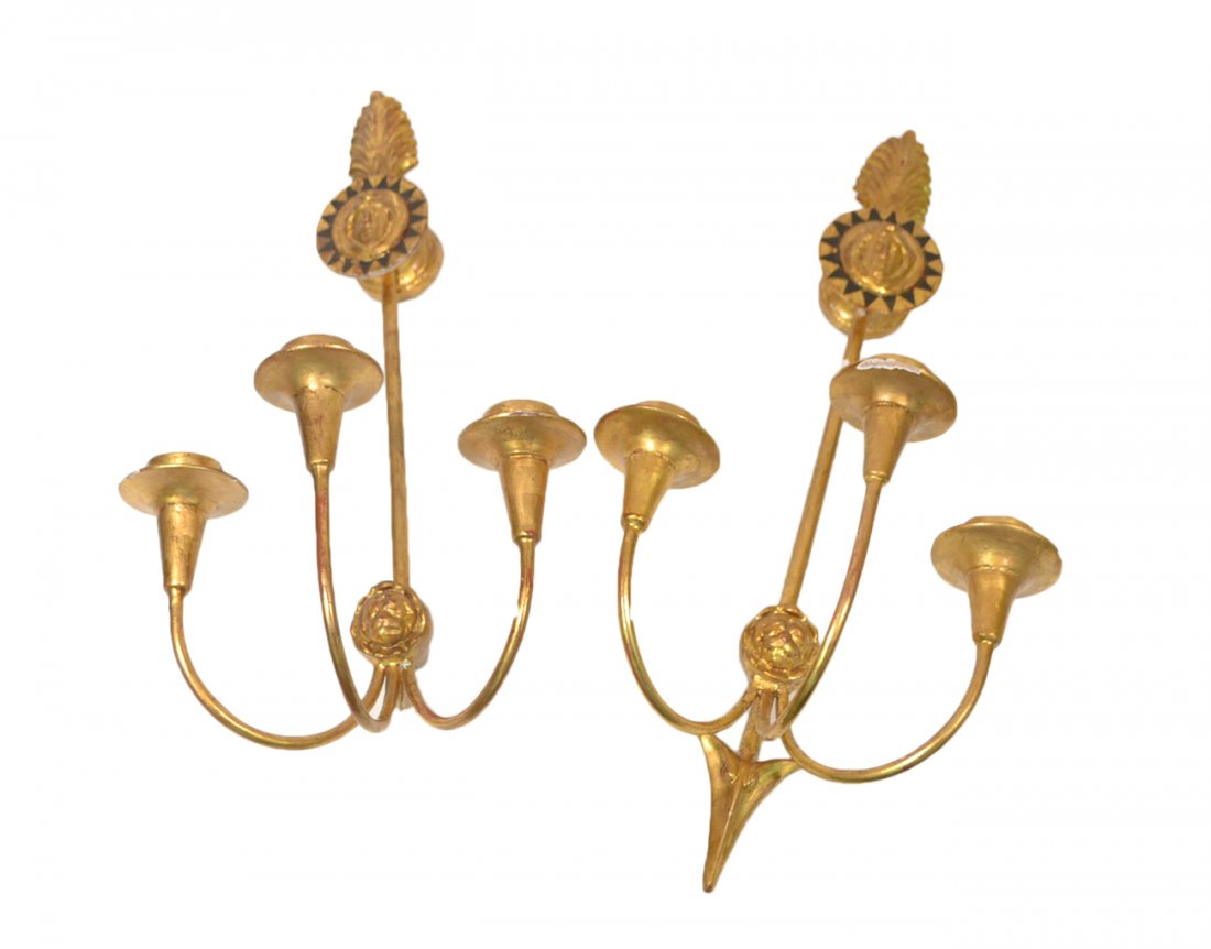 Pair French Empire-Style Sconces: Empire-style arrow-form sconces, each bearing mask of Apollo and palmetto finial, with three arms issuing from icon head. Not electrified. [25" H]. Loss to gilding, one arrowhead missing.