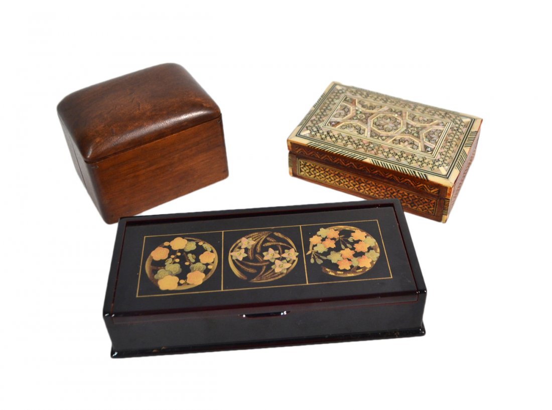 Three Decorative Boxes: Three decorative boxes consisting of one black lacquered box, one box with inlaid ornamentation and one wooden box fitted for cigarettes. [Largest box: 9 1/2" W x 4 1/4" D x 2" H]. Overall good condit