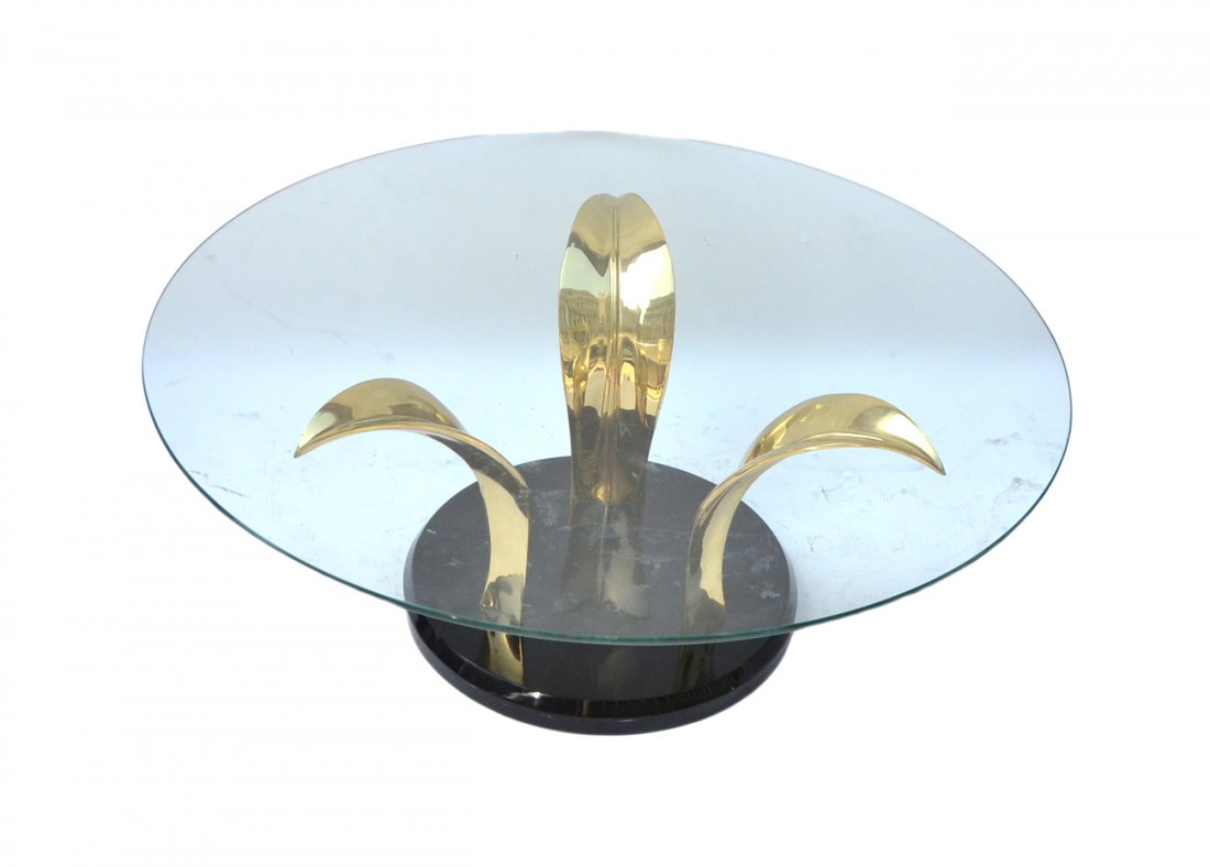 Glass Top Coffee Table with Brass Base: Circular shaped glass-top coffee table on brass base. USA, 20th century. [42" dia, 16" H]. Good condition.