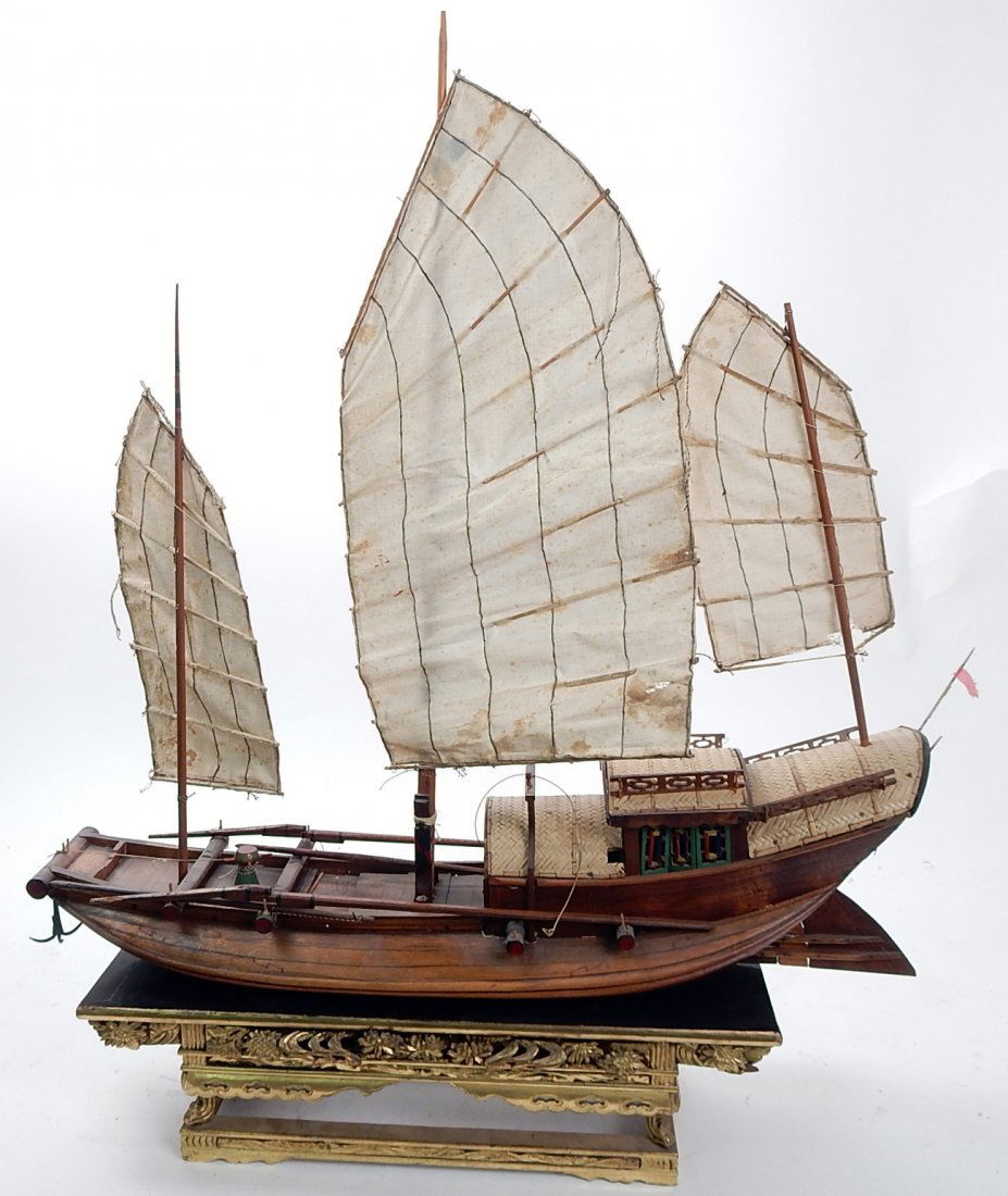 Chinese Model of a Junk: Accompanied by a Chinese carved and gilt wood stand. [Ship model: 23" W x 5" D x 22 1/2" H; Stand: 16 1/2" W x 5 3/4" D x 4 1/4" H].