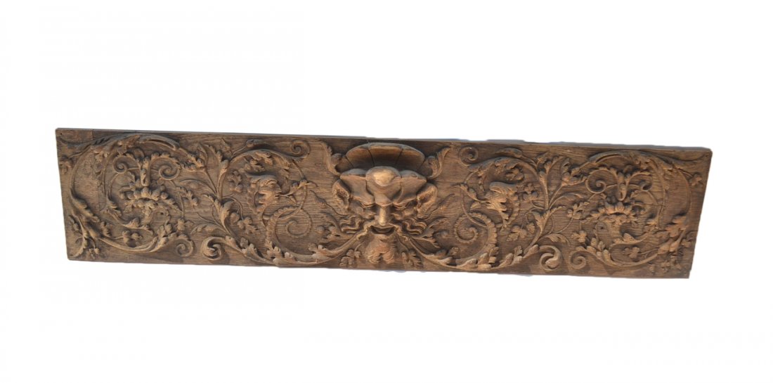 Oak Frieze Carved Mask with Scrolls: Carved oak Frieze of grotesque mask centered with foliate scrolls. [3" W x 9 3/4" x 46 1/2"] In good condition.
