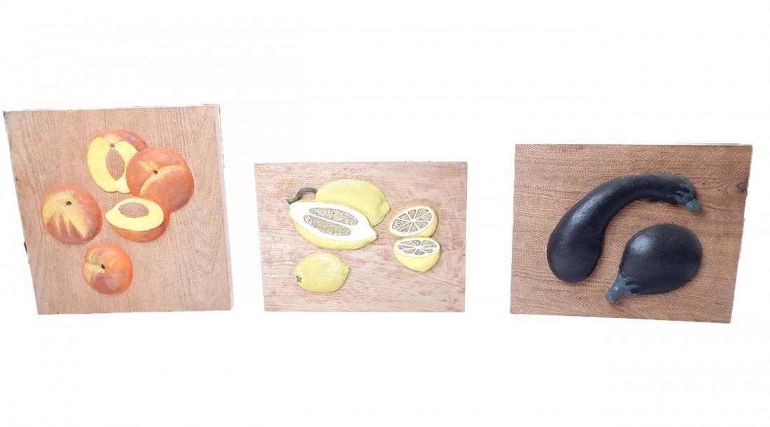 Three carved Pine Plaques: Lot of 3 bas-relief plaques of carved pine wood. Depicts peaches, lemons, and eggplants. Peaches: [10" x 9 1/2"] Lemons: [9 3/4" x 7 3/4"] Eggplants: [10" x 8"] In good condition.