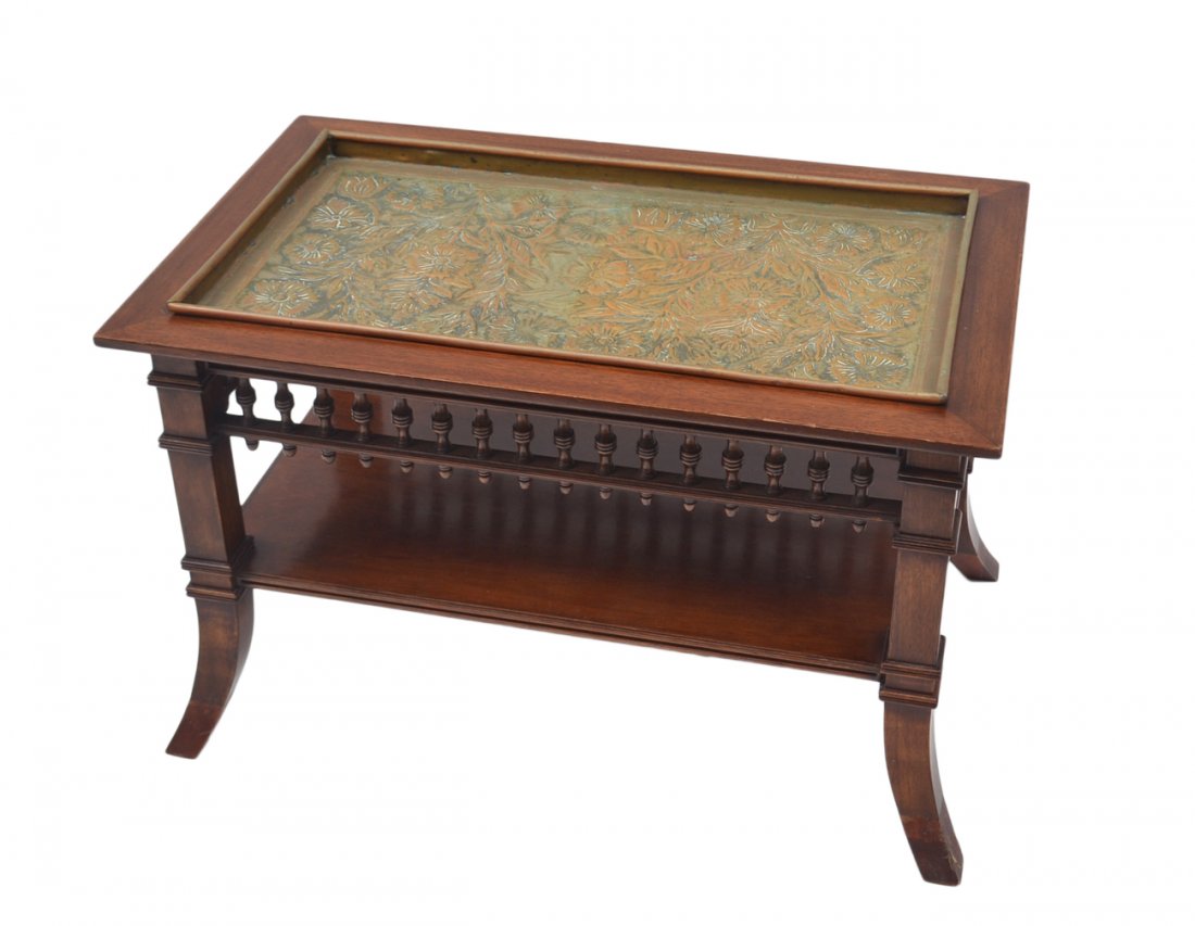Eastlake-Style Tray Top Table: Two-tier mahogany low table with turned accents and splayed feet. Features a brass finish copper tray top with floral repoussé decor. [27 3/4" W x 17" D x 17 1/4" H]. Previously restored; some wear.