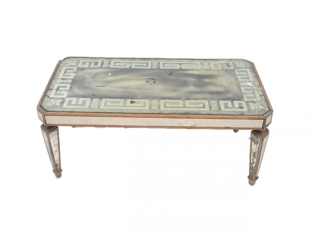 Mid-Century Mirrored Cocktail Table: All-over mirrored cocktail table with distressed silvered wood trim, smoked mirror top with Greek key border motif. [40" x 20" 17 3/8"]. Wear at edges, one mirrored inset on leg cracked, another repla