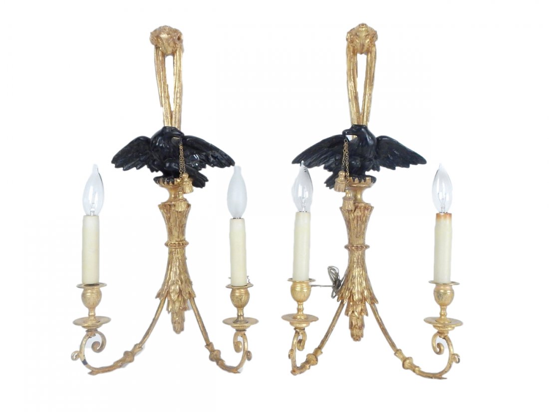 Pair of American Empire Style Sconces: Vintage 2-arm gilt carved wood sconces with ebonized eagle finials. [11 1/4" W x 6 1/2" D x 23 1/4" H]. Wear; one wing broken.