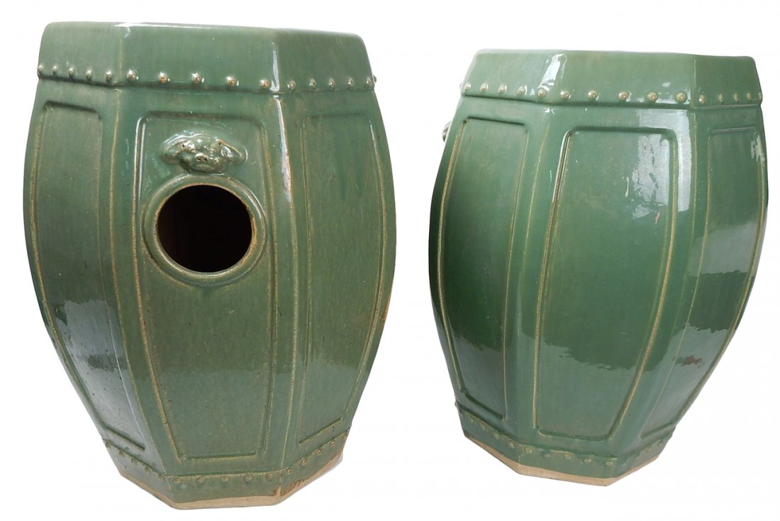 Two Asian Celadon Glazed Pottery Stools: Two celadon glazed pottery stools, octagonal shape with foo dogs above large pierced circles on opposite sides [Each: 14" Dia. x 19" H]. In good condition. From the Estate of Charles Lamb.