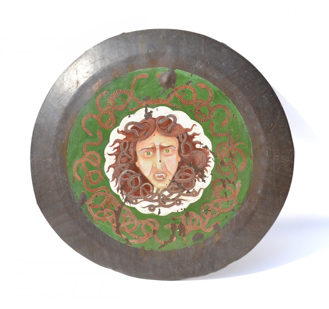 Bronze Shield with Painted Medusa Head: Bronze shield of Medusa's head with a border of snakes on a green ground. [40" Dia]. Paint flaking, loss to painted image, sold "as is". From the Estate of Charles Lamb.