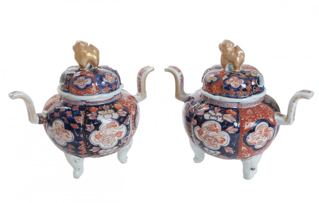 Pair of Ceramic Asian Incense Pots: Pair of ceramic incense pots. Each on tripod feet with dog finial, foo dog and foliate ornamentation on red and blue background. [7" H approx]. Repair to finial on one cover, otherwise in good conditi