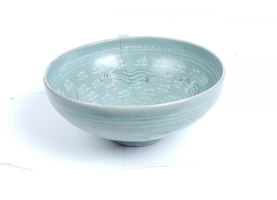 Antique Chinese Celadon Bowl: Ring footed bowl with leafy rosette exterior decor and interior, featuring four stylized phoenix. 13th century type bowl with interior kiln bubble and stress cracks. [8" Dia. x 3 1/8" H].
