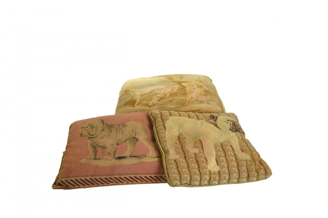 3 Pillows with Dog Motifs: Comprised of two needlepoint pillows of bulldogs, and on tapestry pillow of a hunting dog with pheasants and rabbit. [Largest: 24" x 21"; Smallest: 16" x 15"]. Fading, stains and tears. All sold "as i