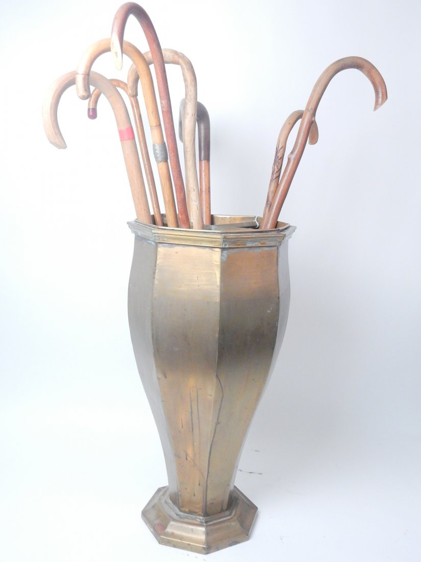 9 Walking Sticks with Brass Stand: Brass umbrella stand containing a various group of canes. From the Estate of Charles Lamb.