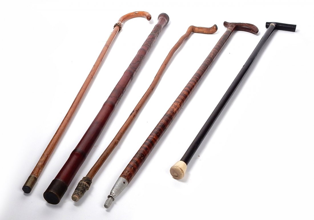 Five Walking Sticks: Group of five walking sticks comprising: one black lacquer inlaid, a bronze mounted, red lacquer Chinese, tiger maple with carved handle and a knotty elm wood. From the Estate of Charles Lamb.