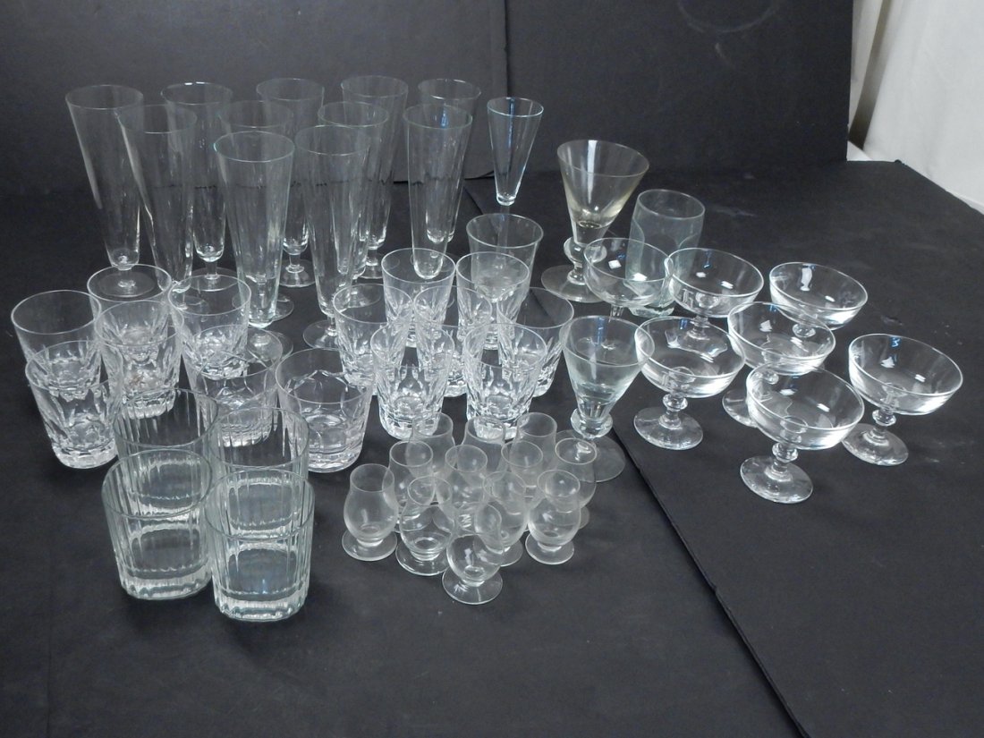 Assortment of Glassware: Collection of clear glass tableware comprising of 10 sorbet glasses enclosed in Steuben bags, one large Steuben glass, set of 11 pilsner glasses, set of 12 shot glasses, and other assorted clear glass