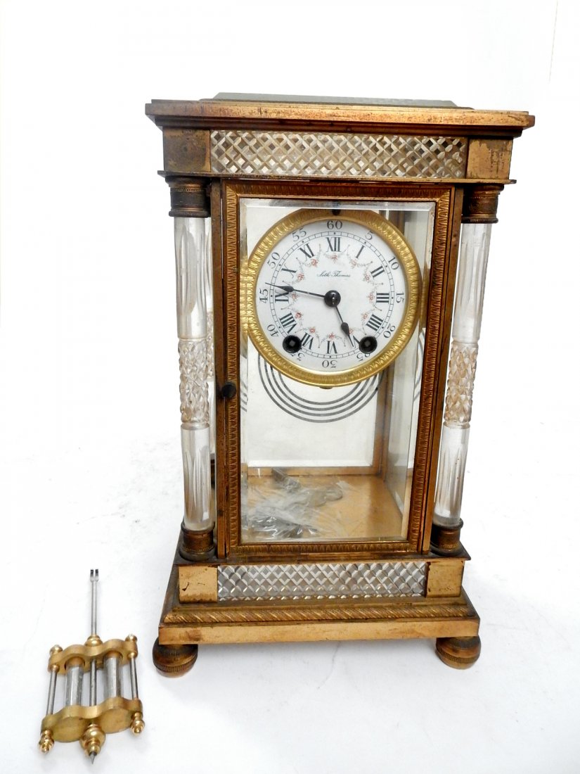 Seth Thomas Regulator Clock: Seth Thomas regulator clock, having a porcelain face, crystal columns and gilded metal with pendulum & keys. [8" x 6" x 12 1/4" H]. Wear to gilding.