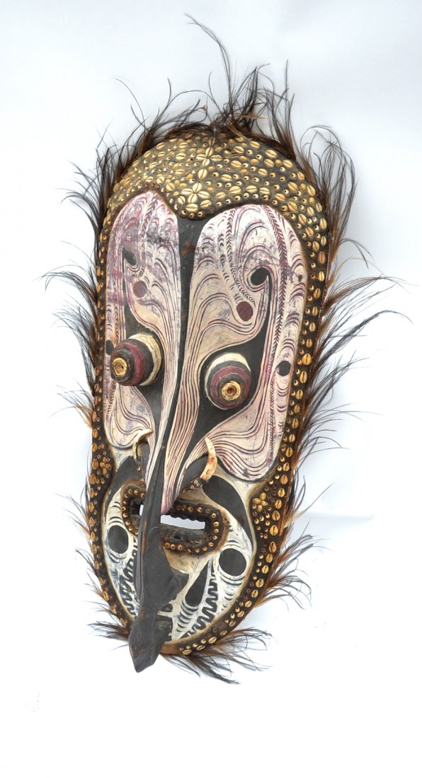 Papua New Guinea Mask: Tambanum carved wood and polychromed mask with feather, shell, and boar's tusk elements. [17 1/2" W x 7 1/2" D x 39" H]. Light wear and losses.