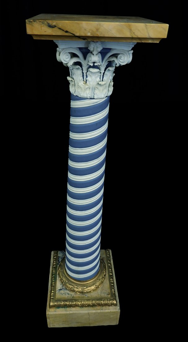Marble and bisque pedestal: Large columnar pedestal with marble plinth base with a blue and white column with a square marble top. [12" square base; 45 1/2" H]. 4 broken accent leaves, minor paint wear at base.