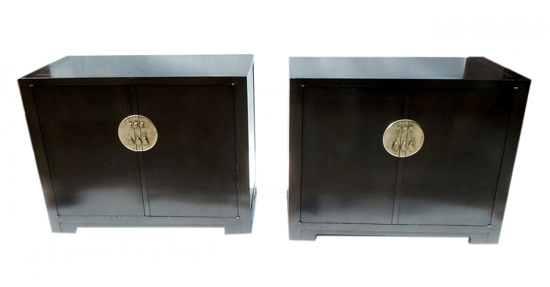 Pair Baker Modern Asian-Style Commodes: Mahogany veneer commodes with large circular nickel-finish escutcheons and two doors concealing three drawers and a lower shelf. [39 3/4" W x 18" D x 32 1/4" H]. Scuffs and light scratches.