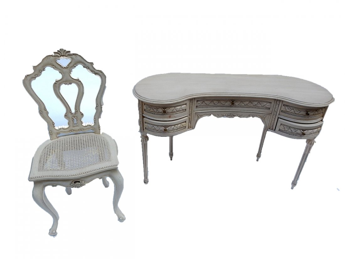 Vanity and Chair: Faux antique cream finish carved vanity with five drawers and a caned chair. [Vanity: 47" W x 17" D x 38" H; To seat: 18 3/4"]. Both in good condition with minor defects.
