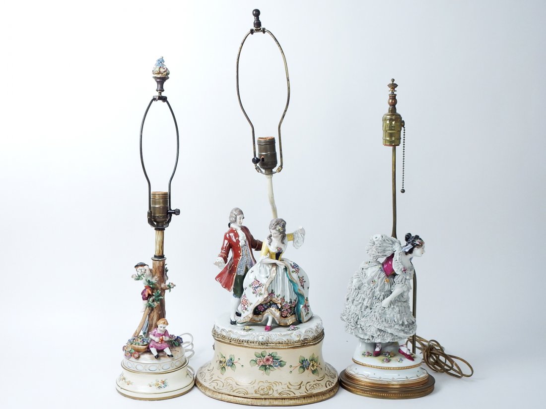 Lot of 3 Porcelain Lamps: Comprises: 1.) Male and female figural lamp, Capodimonte. Loss of hands and fingers. 2.) Dresden type figural lamp, lace. Broken arm, missing. 3.) Porcelain lamp with three children, good condition. [