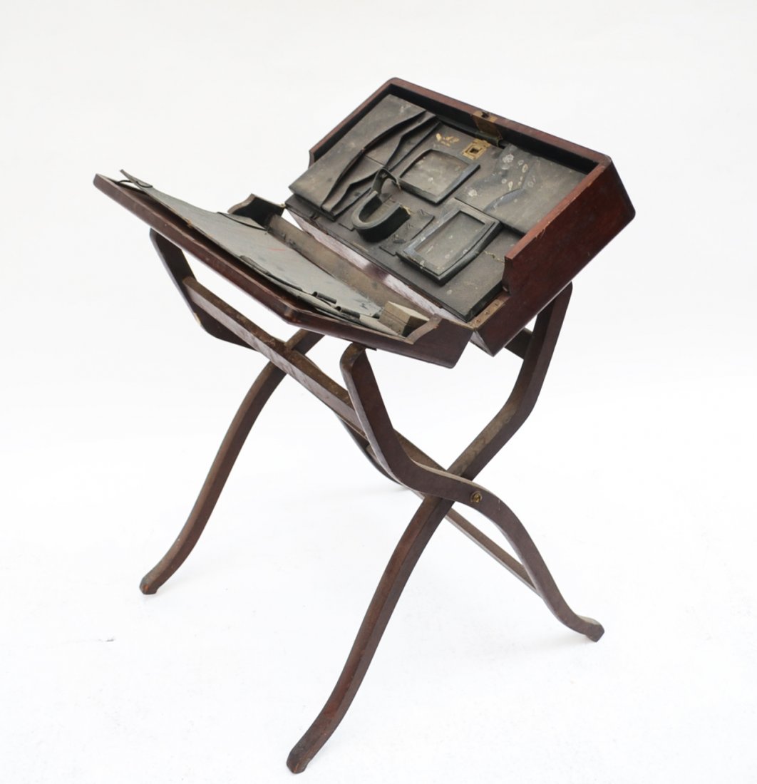 Lap Desk: Mahogany lap desk on stand. [22" W x 37" H x 12" D]. Repair to leg, wear and scratches to finish].