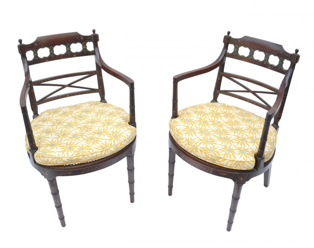 Pair of Painted Edwardian Armchairs: Pair of Edwardian armchairs with painted ornamentation and a cane seat, featuring a contemporary upholstered chair pad. [21 1/2" W x 17 1/2" D x 34" H]; Height to Seat: 20"]. In good condition.