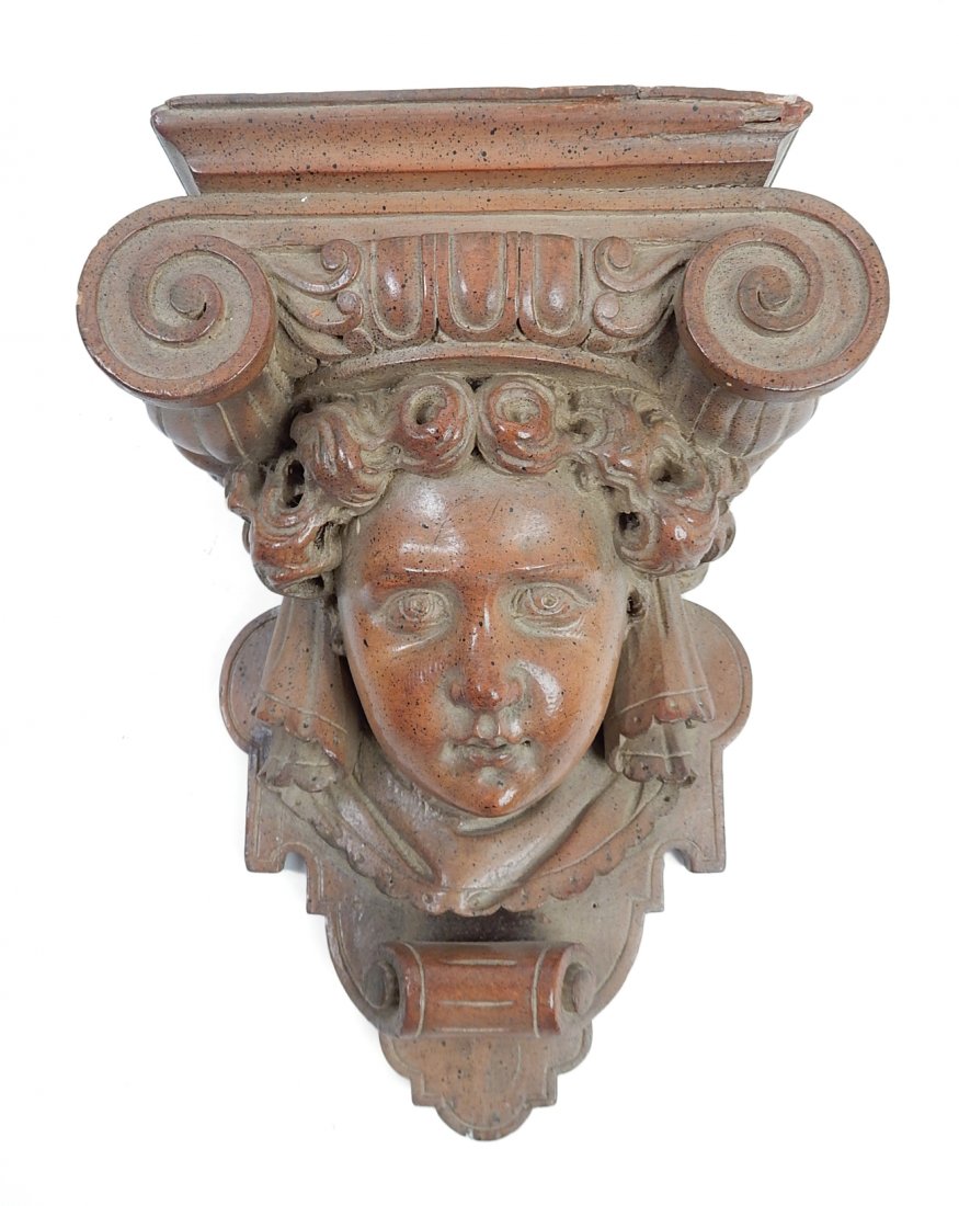 Cherub Face Wall Bracket: Renaissance Revival carved wood wall bracket with a cherub face (mask). [6" W x 8" D x 12" H].