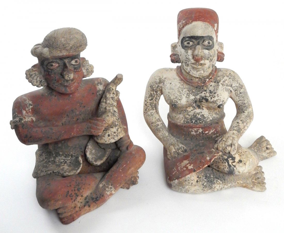Two Pre-Columbian Earthenware Figures: Seated polychromed figures comprising a female and a male musician. Both in traditional tribal costume. [Female: 10 1/2" W x 8 1/4" D x 11 3/8" H; Male: 8 1/4" W x 8" D x 11" H]. Multiple surface defe