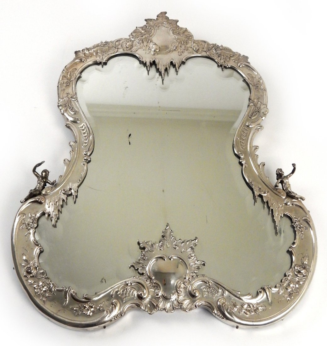 French Rococo Silver Framed Mirror: French Rococo-style silver framed lady's dressing table mirror with two figures. [26 1/2" H x 20" W x 1 1/2" D]. In overall good condition.