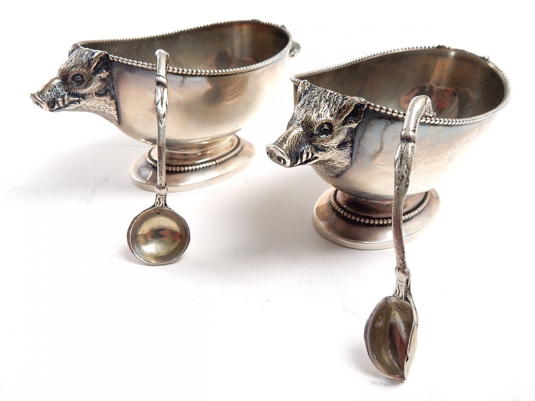 Pair of Rand & Crane Sterling Salts: Pair of salts with boars heads sterling silver "Rand & Crane" with two spoons unmarked and damaged. 3.455 ozt. 4" L x 1 3/8" x 1 5/8"]. In good condition.