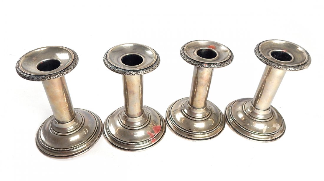 Lot of 4 Weighted Sterling Candlesticks: "International Sterling, cement filled" set of four candlesticks with removable bobeche. [Base: 3 1/2" Dia x 4 3/4" H]. Dents along bases.