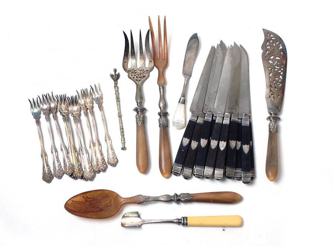 28 Silver Plate Utensils & Flatware: Comprises: Two sets of silver plate serving utensils - salad spoon, fork, cake knife and fork; 12 ebony handled knives, ten art nouveau oyster forks, a melon scoop and mother-of-pearl knife. In good c