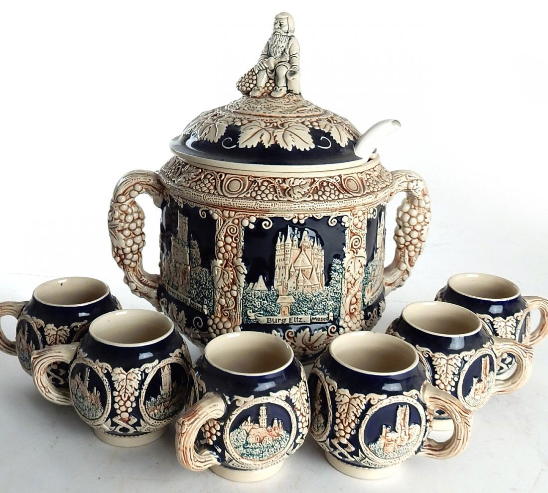 Punch Bowl with Six Cups: Covered punch bowl with earthenware glaze in brown, cobalt blue and green with six matching cups. Ladle included. [13" H x 14" W]. Good condition.