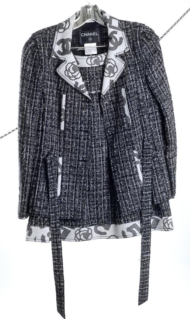 Chanel Ladies Suit, Blazer and Skirt: Navy blue with white and brown highlight tweed, off-white collar with navy floral and Chanel logo motif. Size 38 (Euro). Good condition.