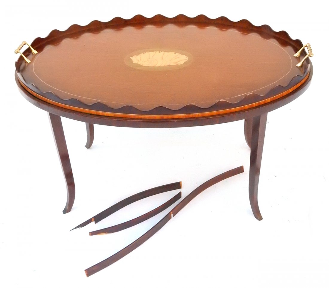 Oval Inlaid Tray Top Table: Oval coffee table with tapered legs. Fitted tray with brass handles, string inlay, and central medallion shell motif. [35 " W x 23 1/2" D x 21" H]. Cross bars broken.