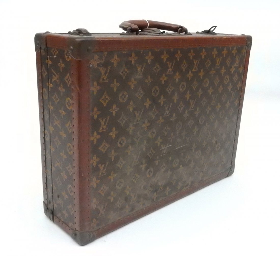Vintage Louis Vuitton Suitcase: Brown leather hard case with iconic logo, contrasting leather edges stamped "LV", and clasps stamped "LV". Keyhole stamped "113032". Interior bears Louis Vuitton gold label and a "Gerardo's Inc." repa
