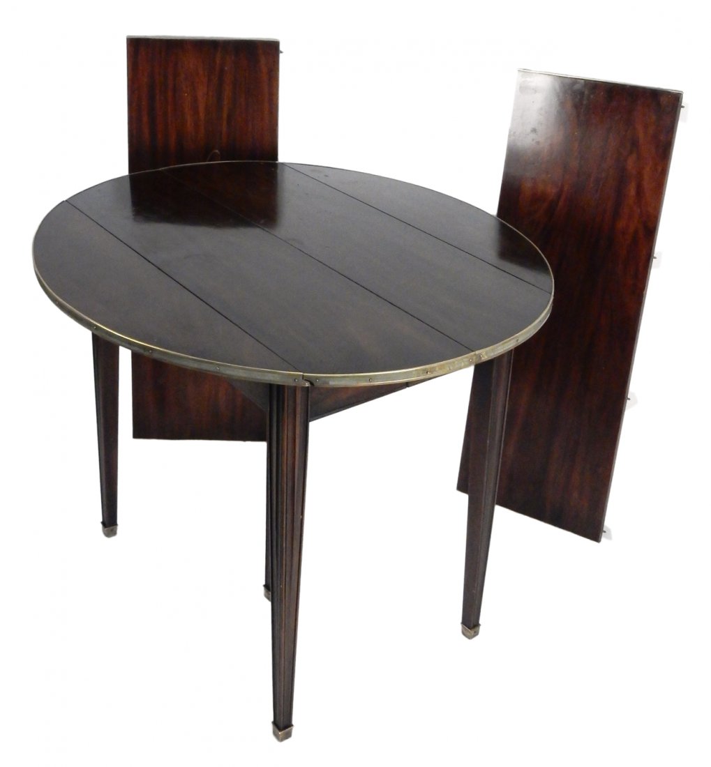 French Mahogany Dining Table: French drop leaf dining room table with brass banded edges. Three leaves. [38" W x 34" D x 29 1/2" H; Leaves each: 13 1/2"]. Wear, scratches, gouges, abrasions.