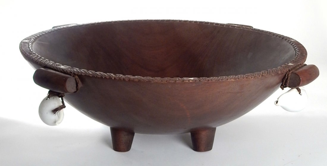 Large Fruitwood African Bowl: Dark wood carved bowl with bone inlays and hanging shells on handles. [26 1/2" Dia. x 8 3/4" H]. Good condition. From Martin Parker / Spencertown Art and Antique Company.