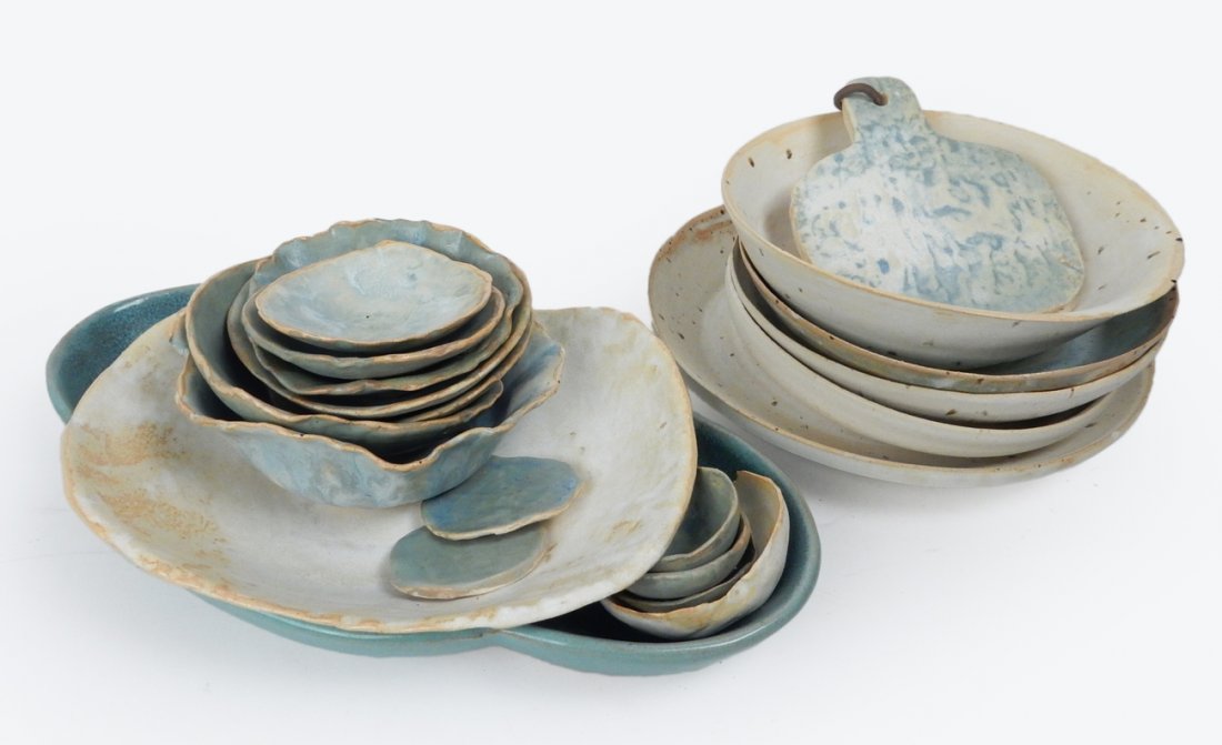 21 Pieces Art Pottery by "Swamp Girl": Collection of 21 pieces of art pottery labeled or inscribed "Swamp Girl". Comprised of plates, bowls, and a serving piece marked "Glidden '47". [Largest: 13" x 7 1/2"]. In overall good condition.