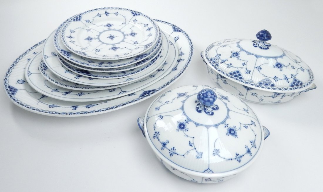 12 Pieces of Royal Copenhagen: Partial blue and white decorated dinnerware including 2 tureens with covers, 3 oval chargers, 5 assorted plates. [Chargers: 12" to 18 1/2"]. In overall good condition.
