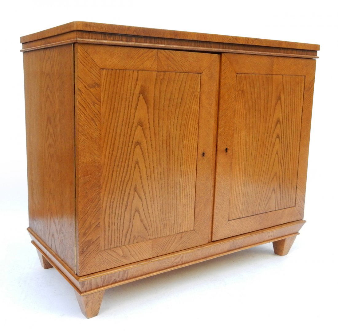 Mid-Century Modern Oak Cabinet: Bears two doors concealing fixed shelf and tapering feet. [41 3/4" W x 20 1/4" D x 35 1/2"]. Missing key.