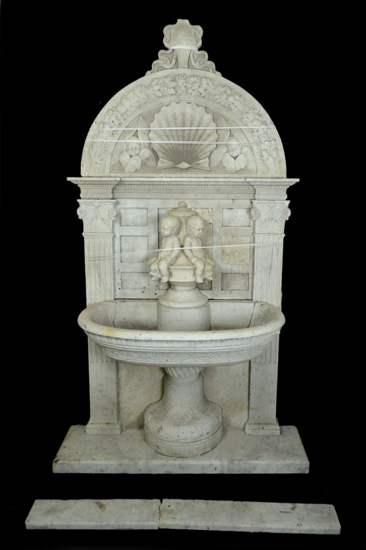19th Century Marble Fountain: Italian fountain having incised, carved decorations with two seated cherubs and an intricately carved pediment including acanthus leaves, wheat sheathes, flowers, and others. [49 1/2" L x 4 1/2" D x 8