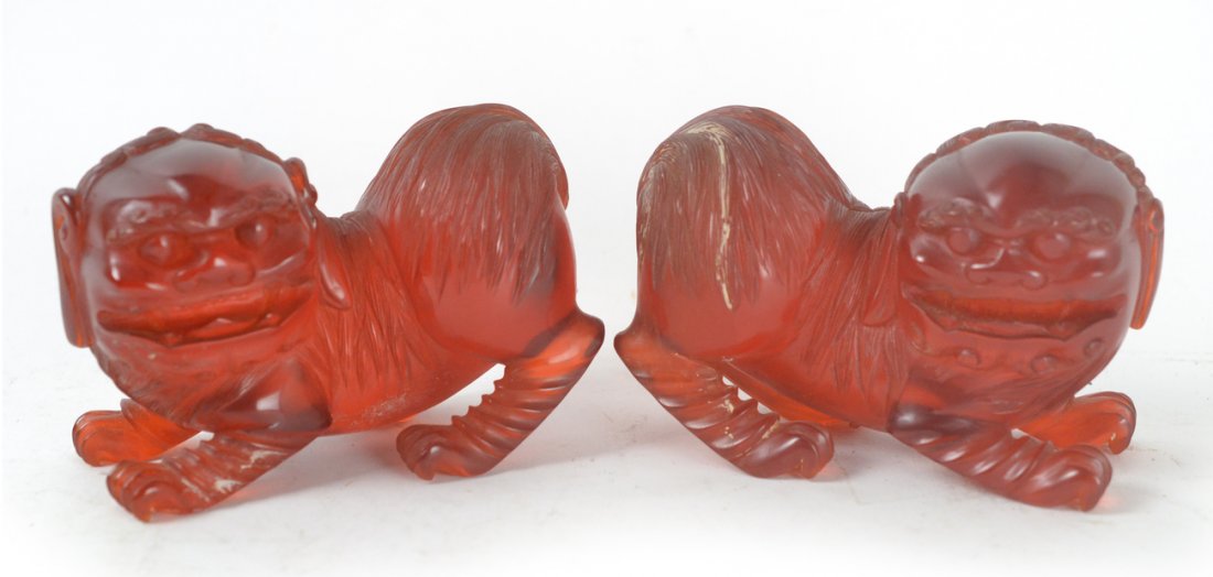 Pair of Red Acrylic Foo Dogs: Carved carnelian color opposing foo dogs. [Each: 5 3/4" W x 2 7/8" D x 4" H]. Good condition.