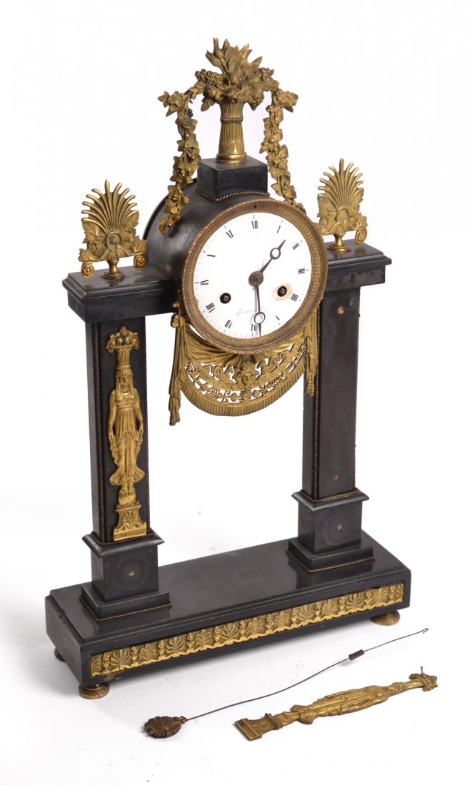 19th C. French Mantle Clock: Ebony marble and bronze dore mantle clock, with figural appliques on columns with garland and pierced bronze decor, enamel face. [13" W x 4" D x 22" H]. Loose appliques. Works not tested.